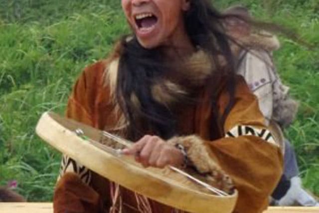 Foto de um indígena com tambor na mão cantando e dançando. A foto ilustra o artigo "O que é Xamanismo?" do site Ori Mystyco.